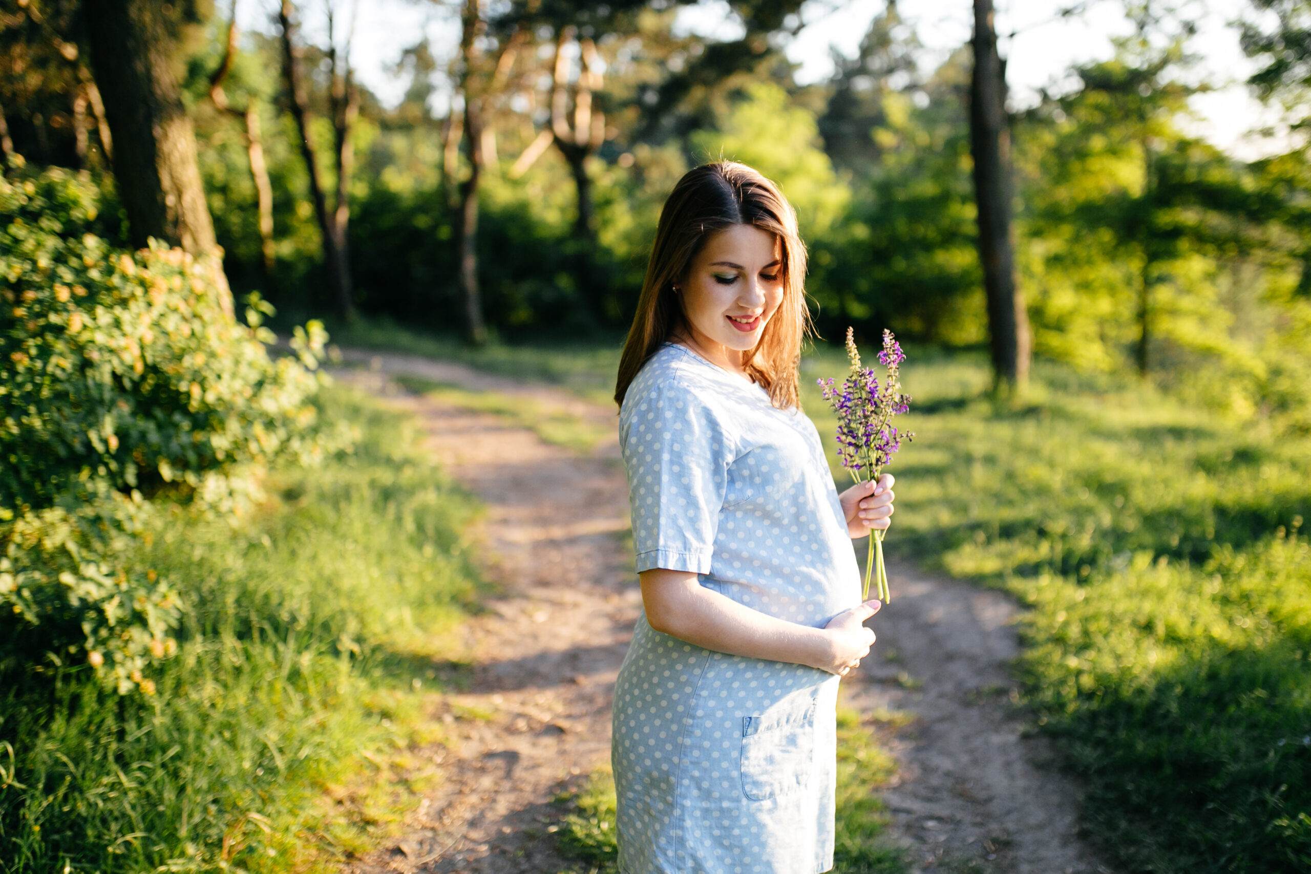 young happy beautiful couple in love walking together on grass and trees park landscape